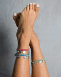 Set of three ankle bracelets with charms, worn by model.